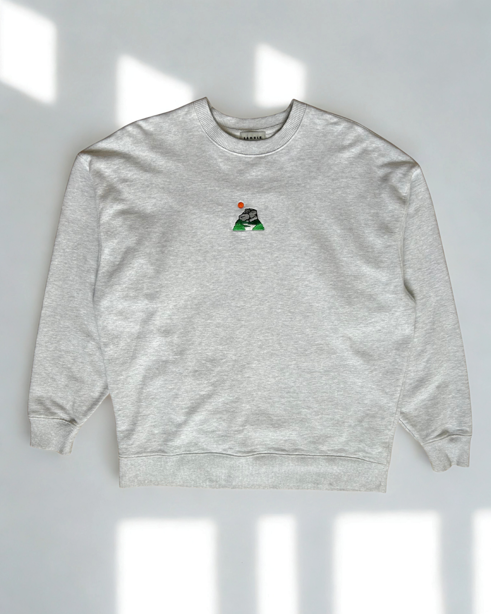 Peak District Sweatshirt displayed flat with embroidered gritstone edge and sun artwork.